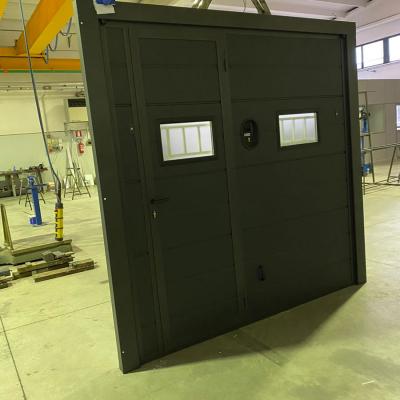 Porta basculante coibentata con pannello tipo tocantis ferro micaceo, telaio verniciato in tinta con il pannello, completa di portina pedonale, oblò in vetro opalino con inferiata interna, automazione a due motori e sblocco per esterno